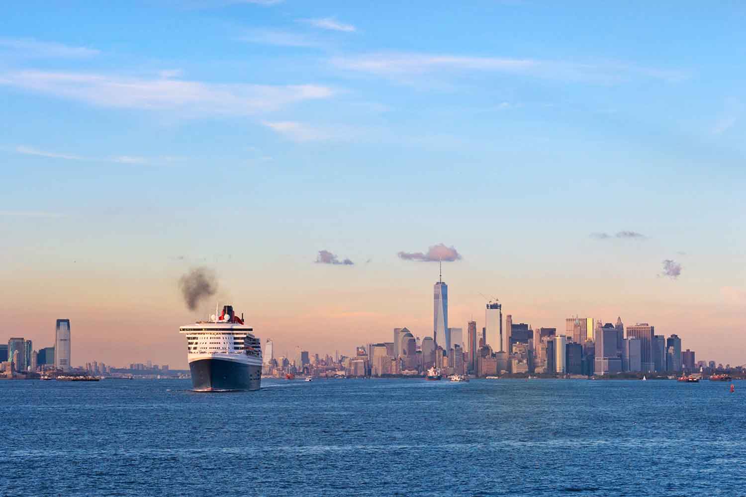 Cruise ship heading to the skyline of New York in the distance