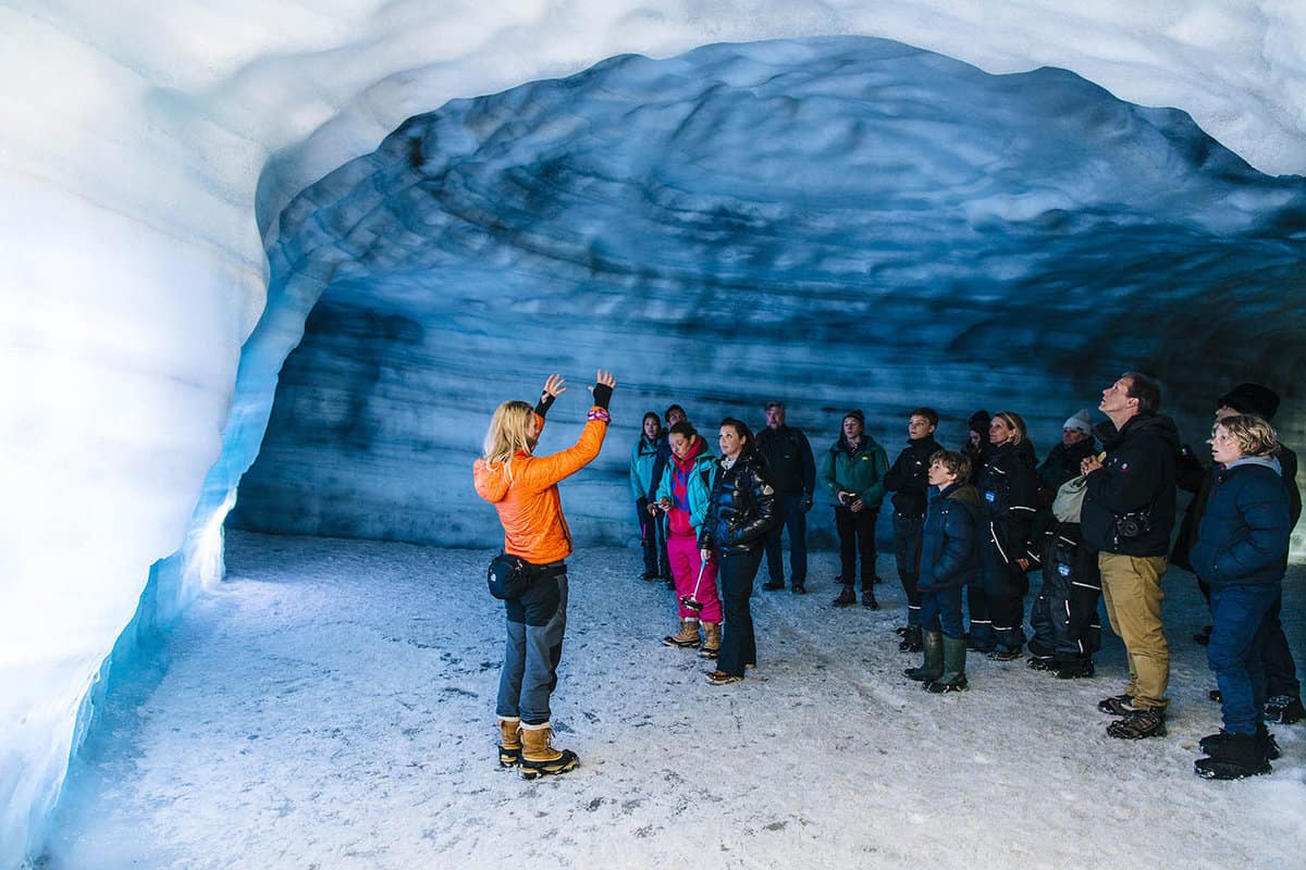 tour group in an ice cave with tour leader explaining how they are formed