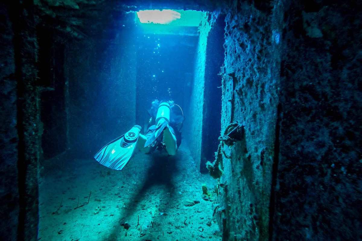 Diver swimming trhough corridor of USS Oriskany wreck, Pensacola