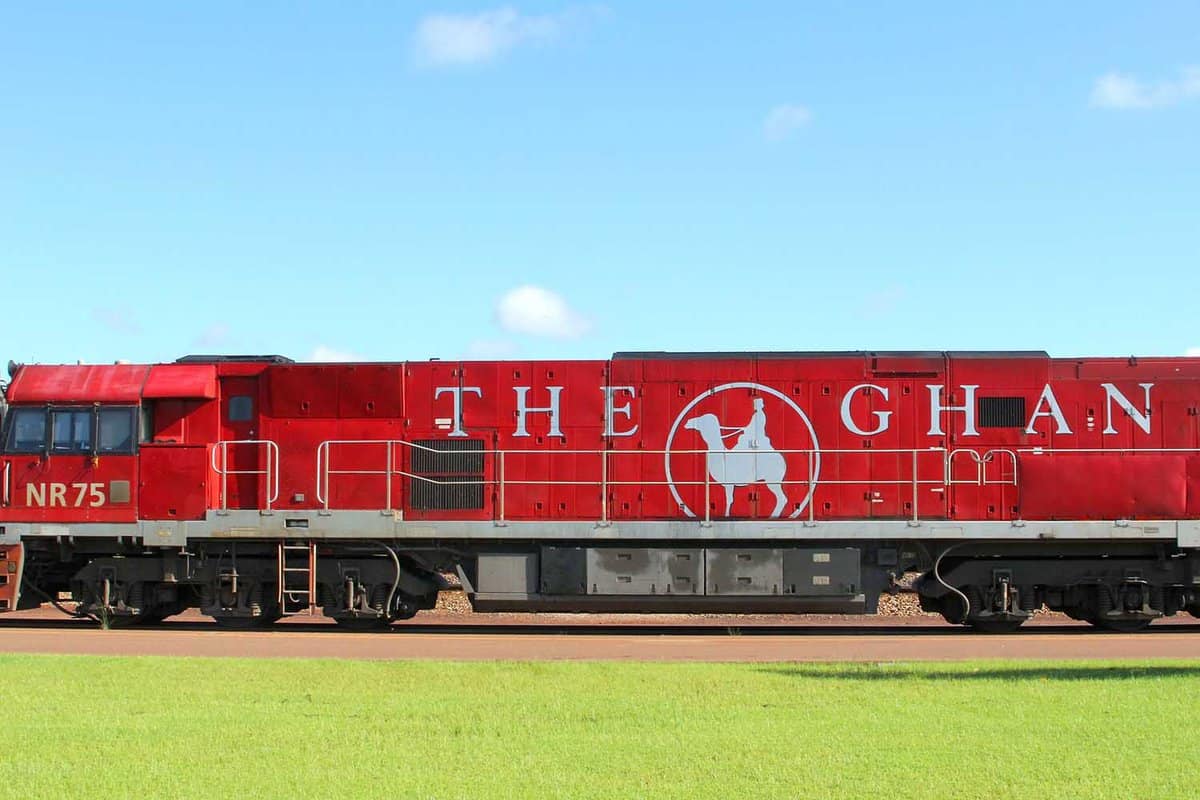 Red locomotive and logo of The Ghan train at railway station. The Ghan connects Darwin, Katherine, Alice Springs, Port Augusta, Adelaide through Australian Outback.